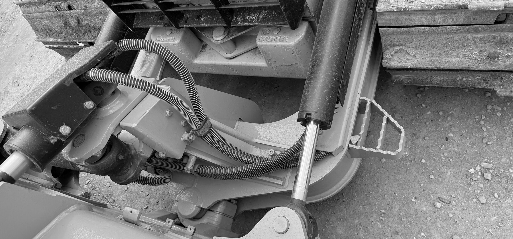 A chrome hydraulic cylinder rod extended beside a structural mount on a dozer's push frame