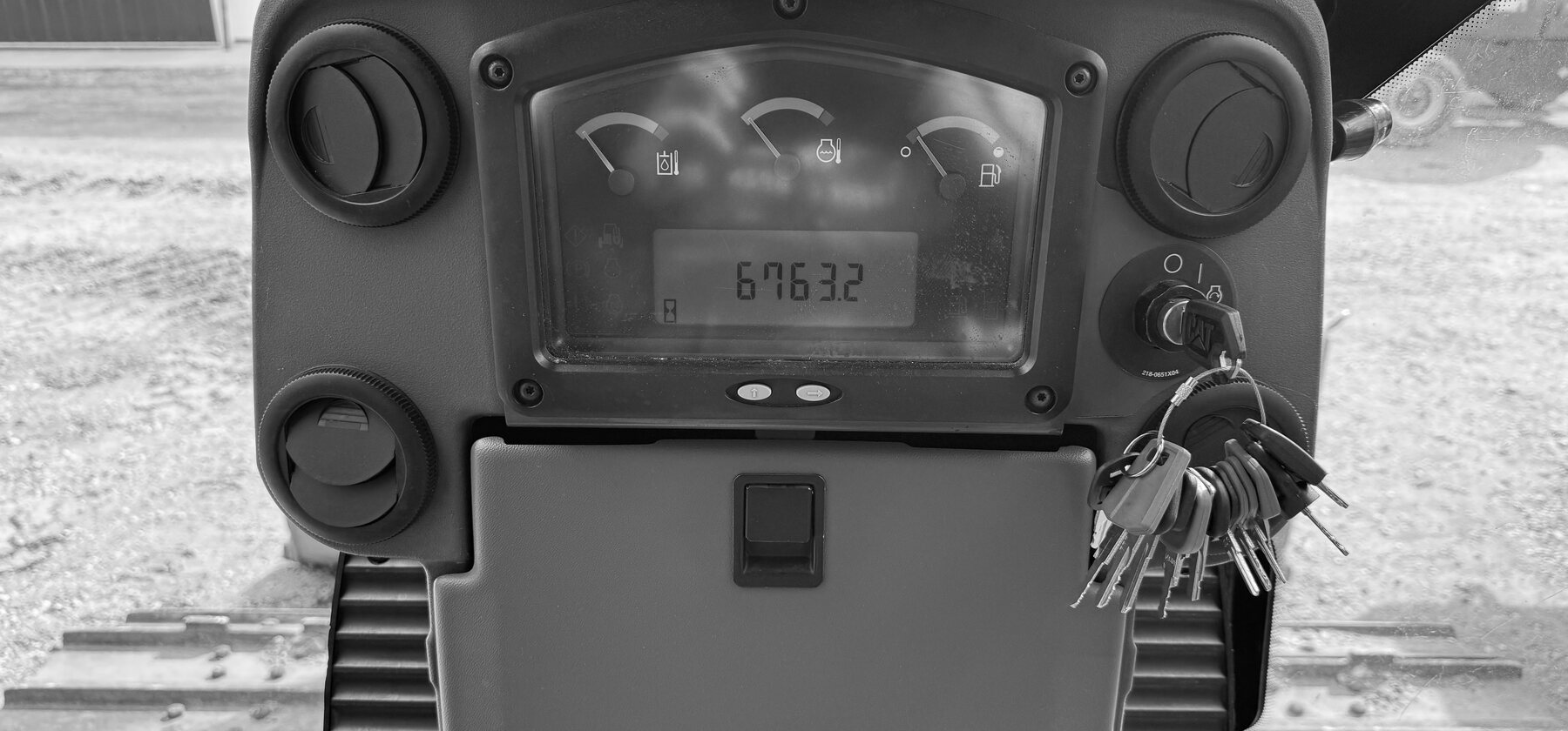 An hour meter, gauges and ignition keys on a dozer dashboard