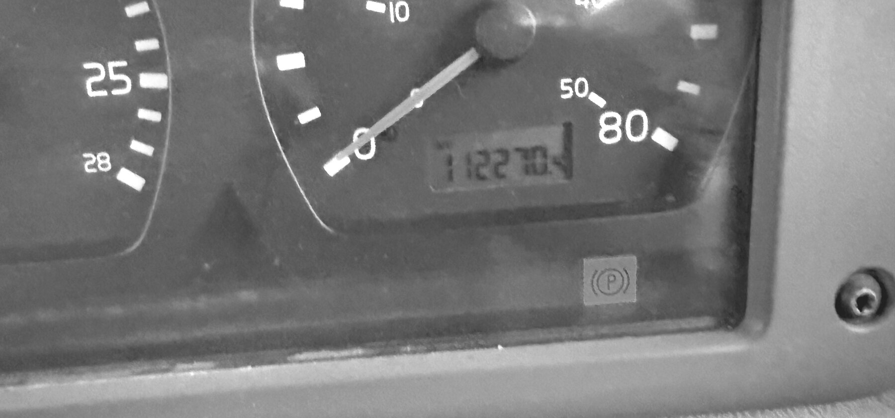 A speedometer and parking brake warning light on a rock truck instrument cluster