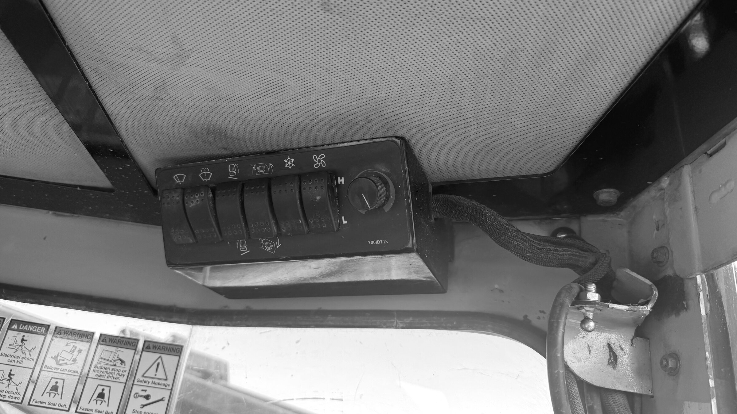 The overhead switch console inside a machine cab, seen from the seat
