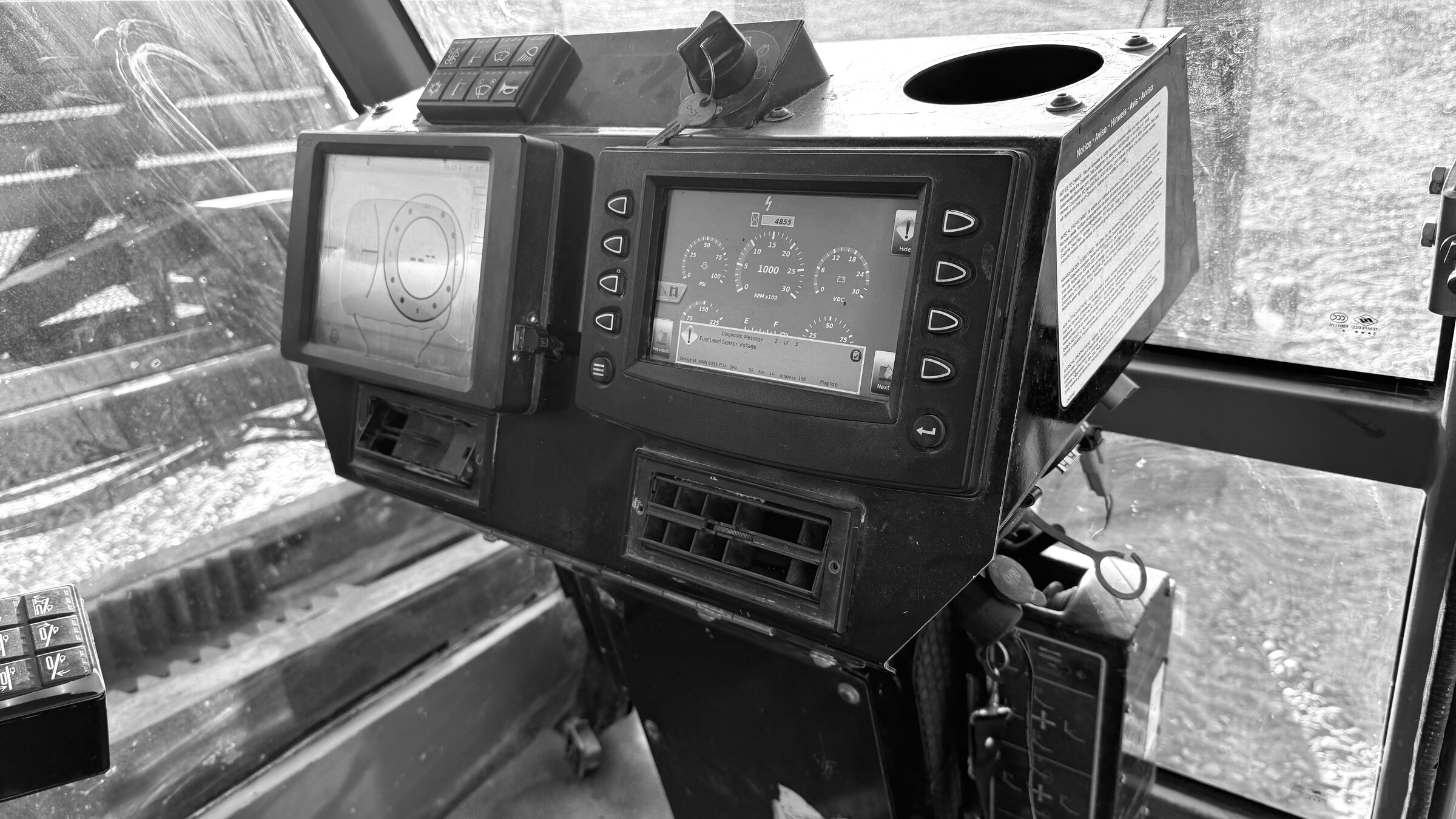 An operator's console in a drill cab: two screens, the keypad and the levers beside them